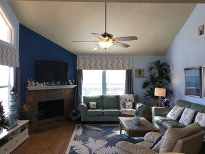 Spacious living room with wood burning fireplace.
