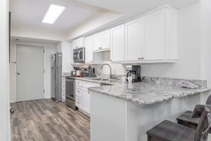 Kitchen - The fully stocked kitchen boasts gleaming stainless appliances, stylish granite counters, and endless possibilities for culinary creativity.