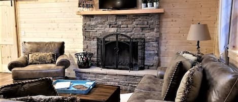 Wood burning fireplace and Roku TV.  Books and games in coffee table.
