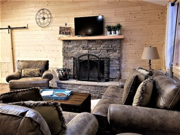 Wood burning fireplace and Roku TV.  Books and games in coffee table.
