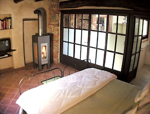 Bedroom with TV and wood burning stove.