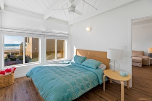 Queen size bed in one of the bedrooms with views of the ocean. 