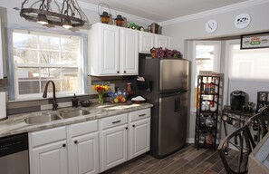 Kitchen is stocked with necessities accompanied by thorough coffee bar.