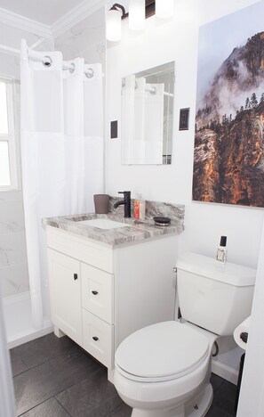 "White and bright" updated bathroom with matching granite in the kitchen.