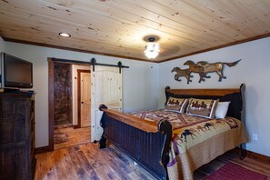 The master bedroom has a king size bed. flat screen TV, and adjoining private bathroom with standing shower. A private entrance offers quick access to the outdoor hot tub.