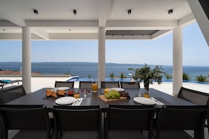 Covered outdoor dining area with modern grill