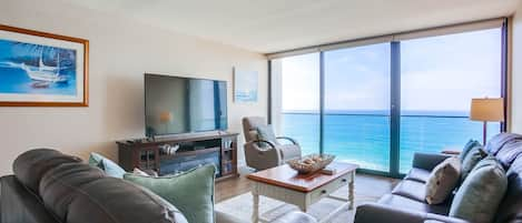 Living room with a queen size sofa bed, TV, recliner and an ocean view