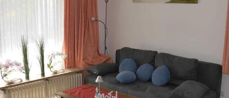 Wohnzimmer mit Sitzgruppe / Schlafcouch