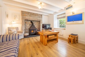 Adanac, Sennen Cove. Ground floor: Sitting room with a wood burning stove and flatscreen television