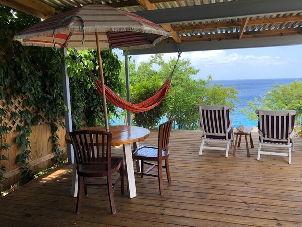 Enjoy your first cup of coffee on the covered deck overlooking the sea.