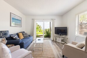 Armchairs, sofa, coffee table, dining room set, and the kitchen