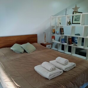 Queen-size bedroom, towels, pillows, bedspread.