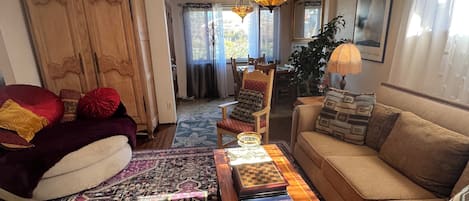 Living room facing the front door and large window with a table and 4 chairs 