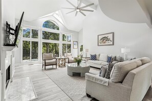 Living Room with Large Windows Overlooking Pool and Lagoon at 11 Cartgate