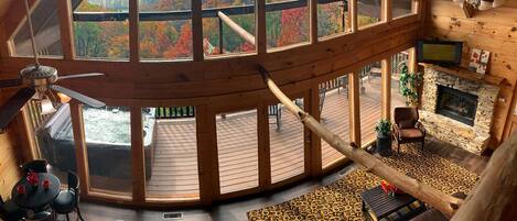 View of living area, pool table, hot tub, deck, fireplace, and dining area.
