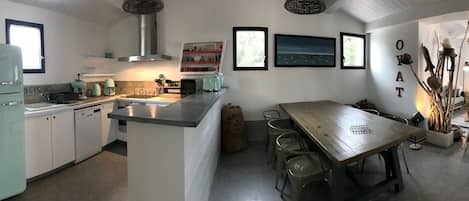 Vue panoramique cuisine, salle à manger, salon.