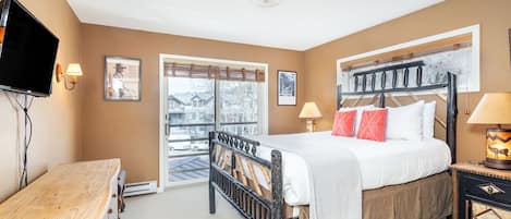 The main bedroom is furnished with a cozy queen bed, flat screen TV, and plenty of space for your belongings.