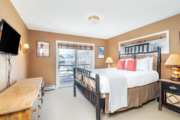 The main bedroom is furnished with a cozy queen bed, flat screen TV, and plenty of space for your belongings.