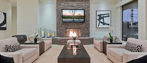 Living Room with large 70" TV,  gas fireplace  and ample seating.