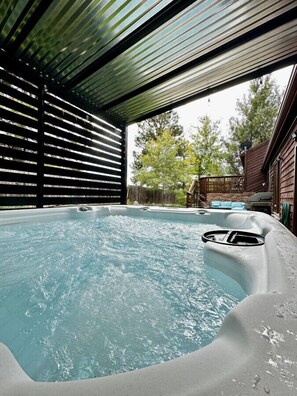 Hot Tub with covered pergola and open to patio, with plenty of seating in your private, fenced backyard. There is also a grill for your use!