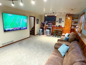 Basement theater room with 85" TV, arcades, 2 sleeper sofas, books, and toys!