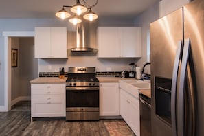 Fully outfitted stainless kitchen with new gas range.