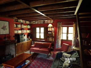 Salon bibliothèque et l'escalier pour monter à une chambre indépendante.