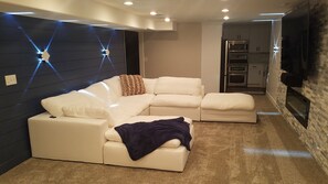 Gorgeous basement family room with white down feather sectional /mega bed