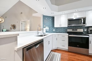 Beautifully updated kitchen with quartz countertops and glass tile backsplash 