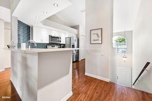 Beautifully updated kitchen with quartz countertops and glass tile backsplash 