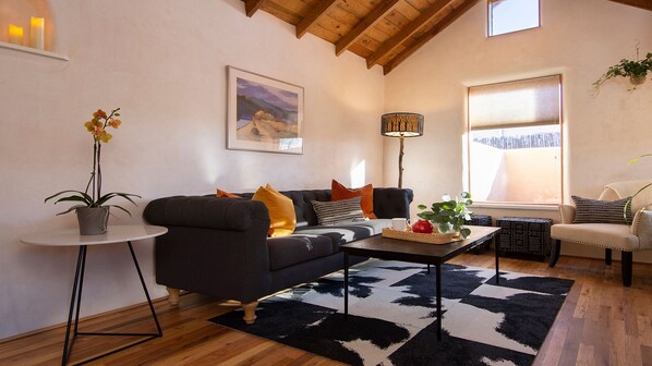 Living room with comfortable seating and natural light. Wood ceilings and floors