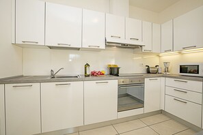 Die voll ausgestattete Küche mit Geschirrspüler, Backofen und Herd