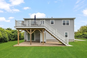 Back Side of House with Deck, outdoor shower and patio area.