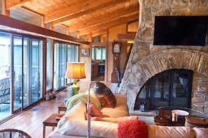 Living Room w/ cathedral ceiling & double-sided chimney looking towards kitchen