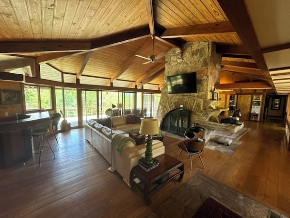 Living room, wet bar, cathedral ceiling looking upon double-sided chimney
