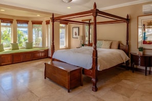 The spacious upstairs bedroom features an en suite bathroom, tasteful decor, and a window seat with breathtaking ocean views.