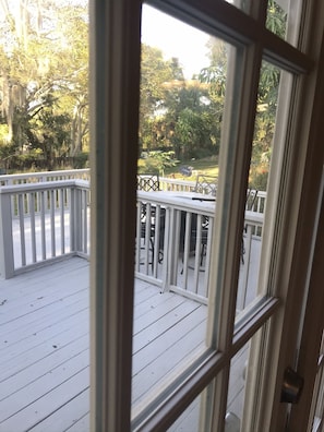 View of back deck with high top table through kitchen French doors.