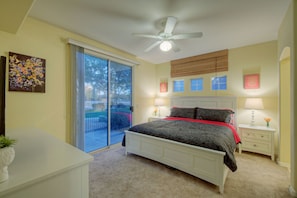 Primary bedroom with king bed has private access to the patio at the back of condo.