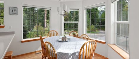 The dining room has large windows in a bay shape.
