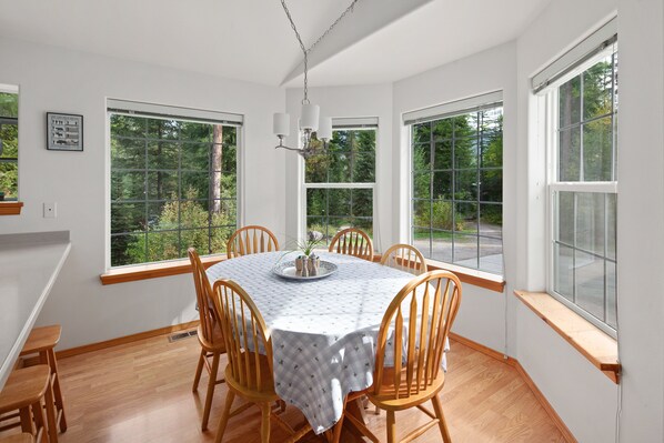 The dining room has large windows in a bay shape.
