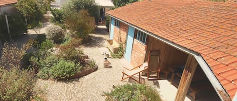 La maison et le préau de l'appartement donnent sur la cour pavée.