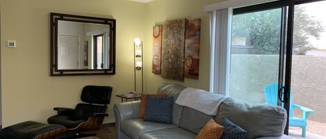 Living room with sliding glass door leading to spacious walled in back yard.