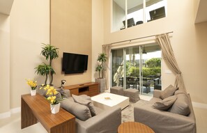 Spacious living room with high ceilings and a smart TV for perfect ambiance.