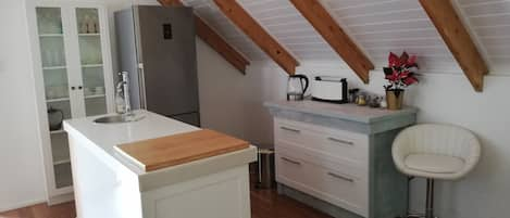 Kitchenette in the loft with prep-bowl dishwasher and fridge.