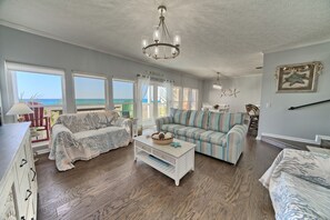 Coastal charm meets comfort in this spacious living and dining area, perfectly framed by breathtaking ocean views