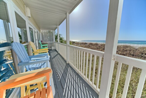 Relax on the colorful deck chairs and soak in the stunning ocean views from this breezy beachfront balcony.