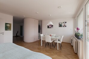 Sleeping area with double bed, dining area, large windows and private balcony