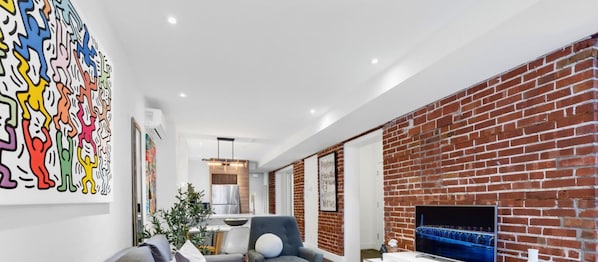 Living Room: Features a queen-size sofa bed with Art Deco design, two armchairs, and a Smart HD TV with access to Netflix, YouTube, and Prime.