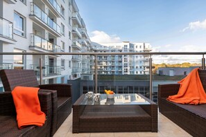 Spacious balcony with outdoor furniture. 