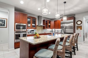 Fully equipped kitchen with stainless steel appliances and a center island with bar seating.